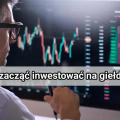 Mężczyzna w okularach analizuje wykresy giełdowe na monitorze, zastanawiając się, jak inwestować na giełdzie.